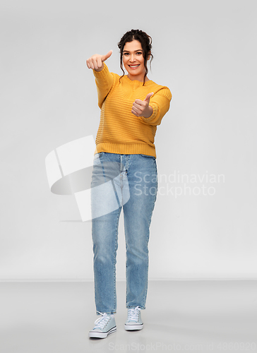 Image of happy smiling young woman showing thumbs up