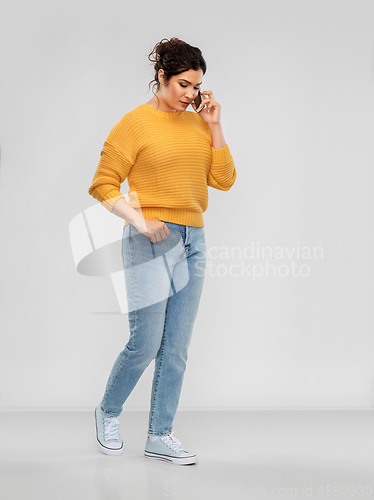 Image of happy young woman calling on smartphone