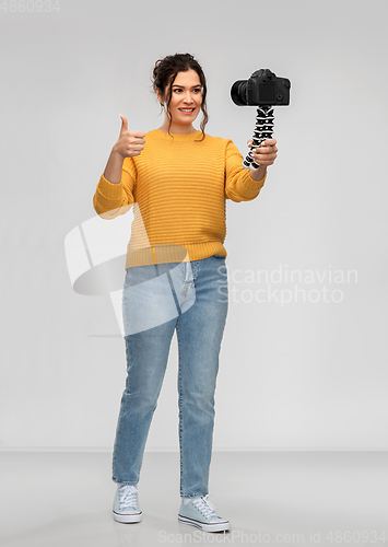 Image of smiling woman blogger with camera recording video