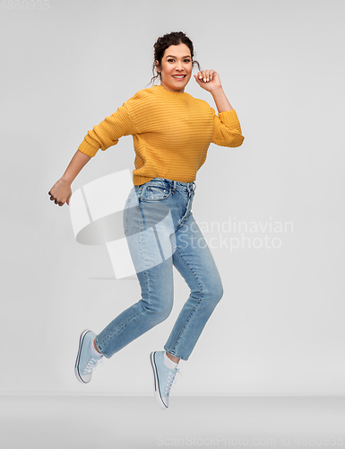 Image of happy young woman with pierced nose jumping