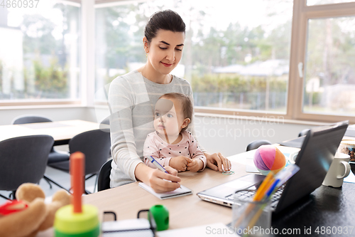 Image of mother with baby working at home office