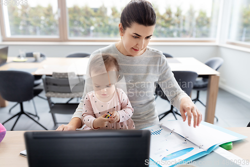 Image of mother with baby working at home office