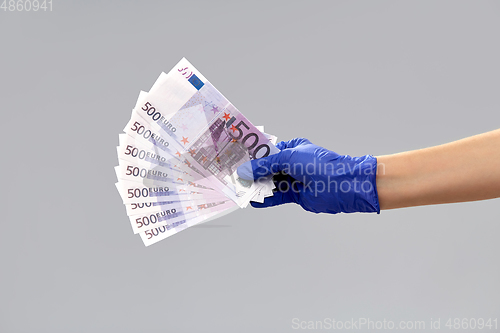 Image of close up of hand in medical glove with money