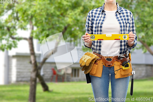 Image of woman builder with level and working tools on belt