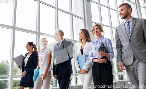 Image of business people walking along office building