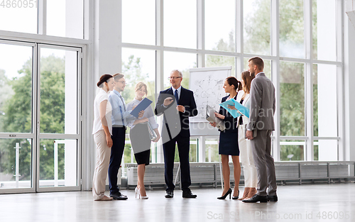 Image of business team with scheme on flip chart at office