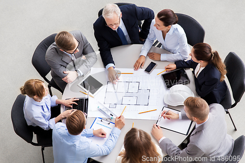 Image of architects with laptop and blueprint at office