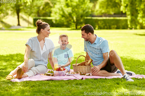 Image of happy family having picnic at summer park