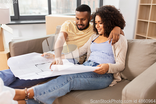 Image of couple with boxes and blueprint moving to new home