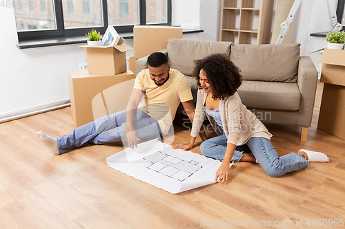 Image of couple with boxes and blueprint moving to new home