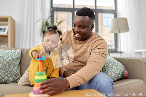 Image of african family playing with baby daughter at home