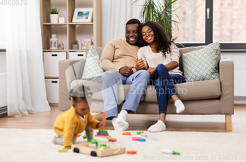 Image of african family with baby daughter playing at home