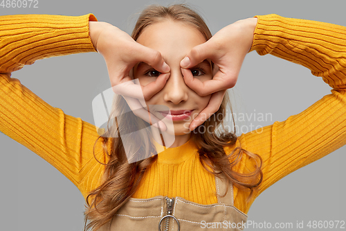 Image of teenage girl looking through finger glasses