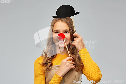 Image of smiling teenage girl with red clown nose and hat