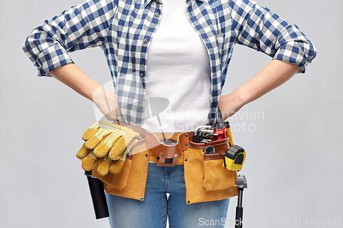 Image of woman or builder with working tools on belt