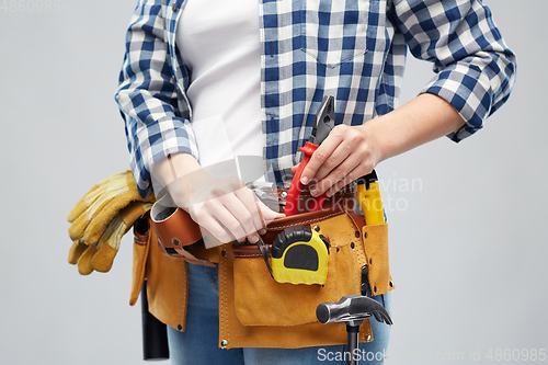 Image of woman or builder with working tools on belt