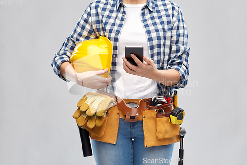 Image of woman or builder with phone and working tools