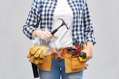 Image of woman with hammer and working tools on belt