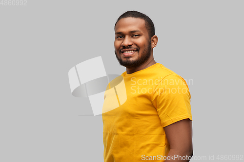 Image of smiling african american man in yellow t-shirt