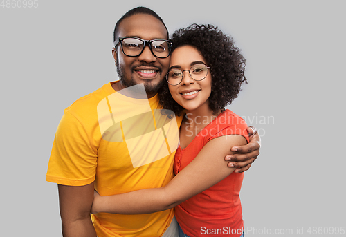 Image of happy african american couple in glasses hugging