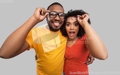 Image of happy african american couple in glasses hugging