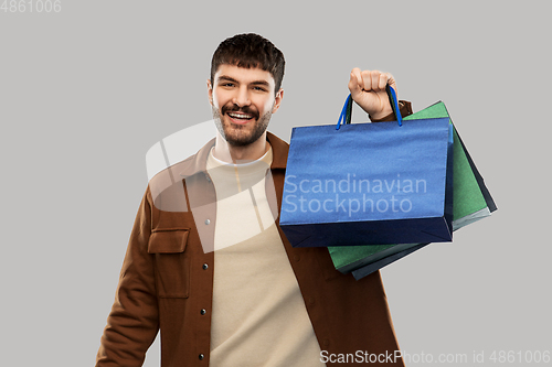 Image of happy smiling young man with shopping bags