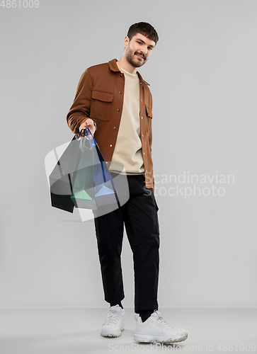 Image of smiling young man with shopping bags