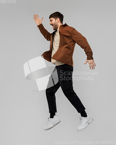 Image of happy smiling young man jumping in air