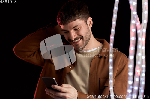 Image of happy smiling young man with smartphone