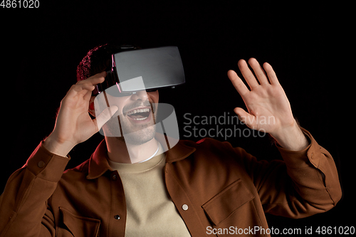 Image of happy man in vr glasses over black background