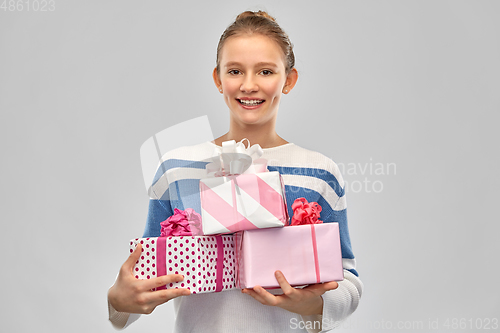 Image of smiling teenage girl in pullover with gift box