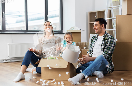 Image of happy family playing with foam peanuts at new home