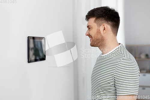 Image of happy man looking at tablet computer at smart home