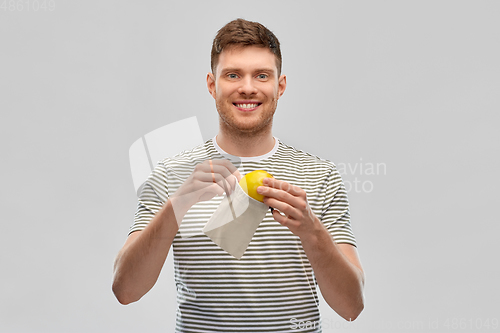 Image of smiling man with lemon in reusable canvas bag