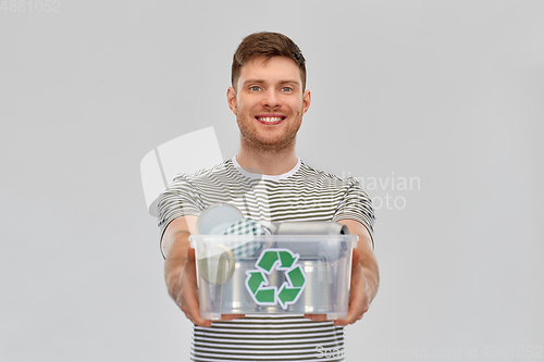 Image of smiling young man sorting metallic waste