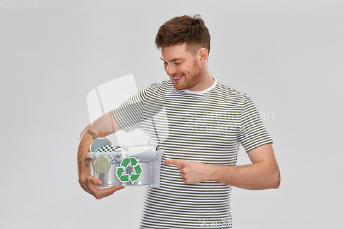 Image of smiling young man sorting metallic waste