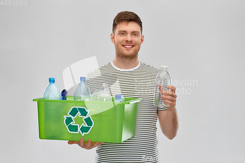 Image of smiling young man sorting plastic waste
