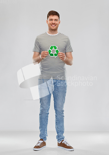 Image of smiling young man holding green recycling sign