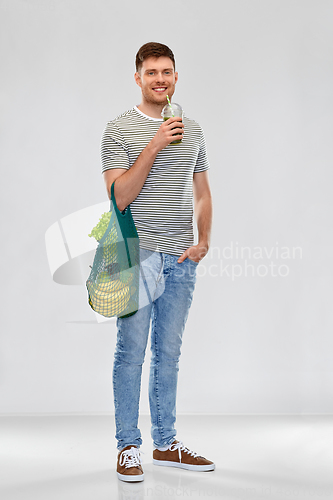 Image of man with bag for food shopping and green smoothie