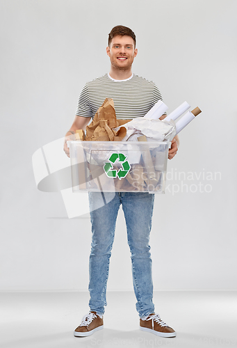 Image of smiling young man sorting paper waste