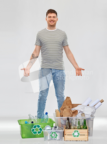 Image of smiling man sorting paper, metal and plastic waste