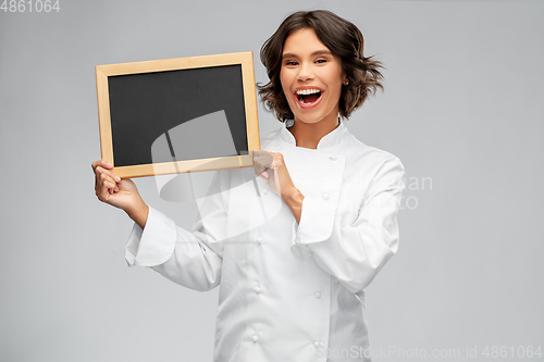 Image of smiling female chef holding black chalkboard