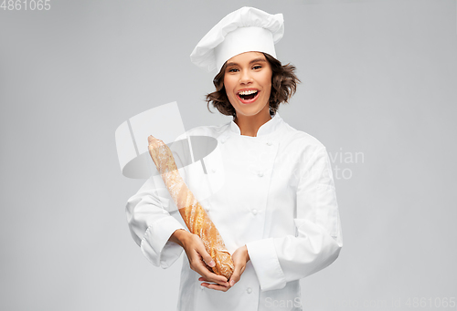 Image of happy female chef with french bread or baguette