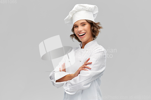 Image of smiling female chef in toque with crossed arms