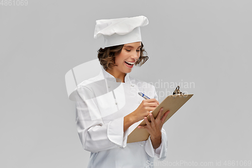 Image of smiling female chef in toque with clipboard