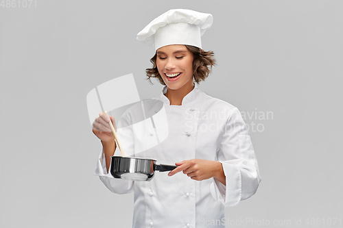 Image of happy smiling female chef with saucepan