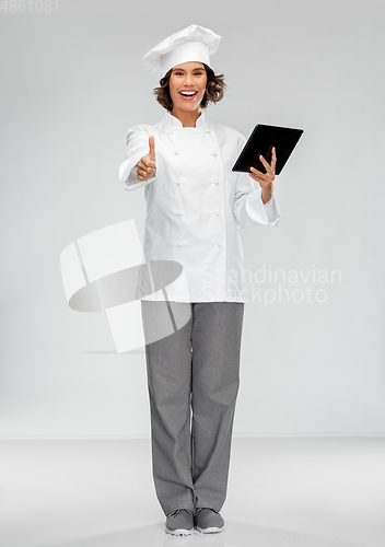 Image of smiling female chef in toque with tablet computer
