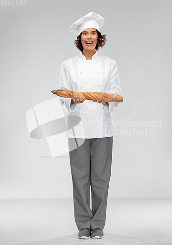 Image of happy female chef with french bread or baguette