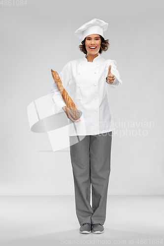 Image of happy female chef with french bread or baguette