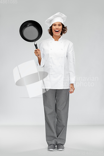 Image of smiling female chef in toque with frying pan